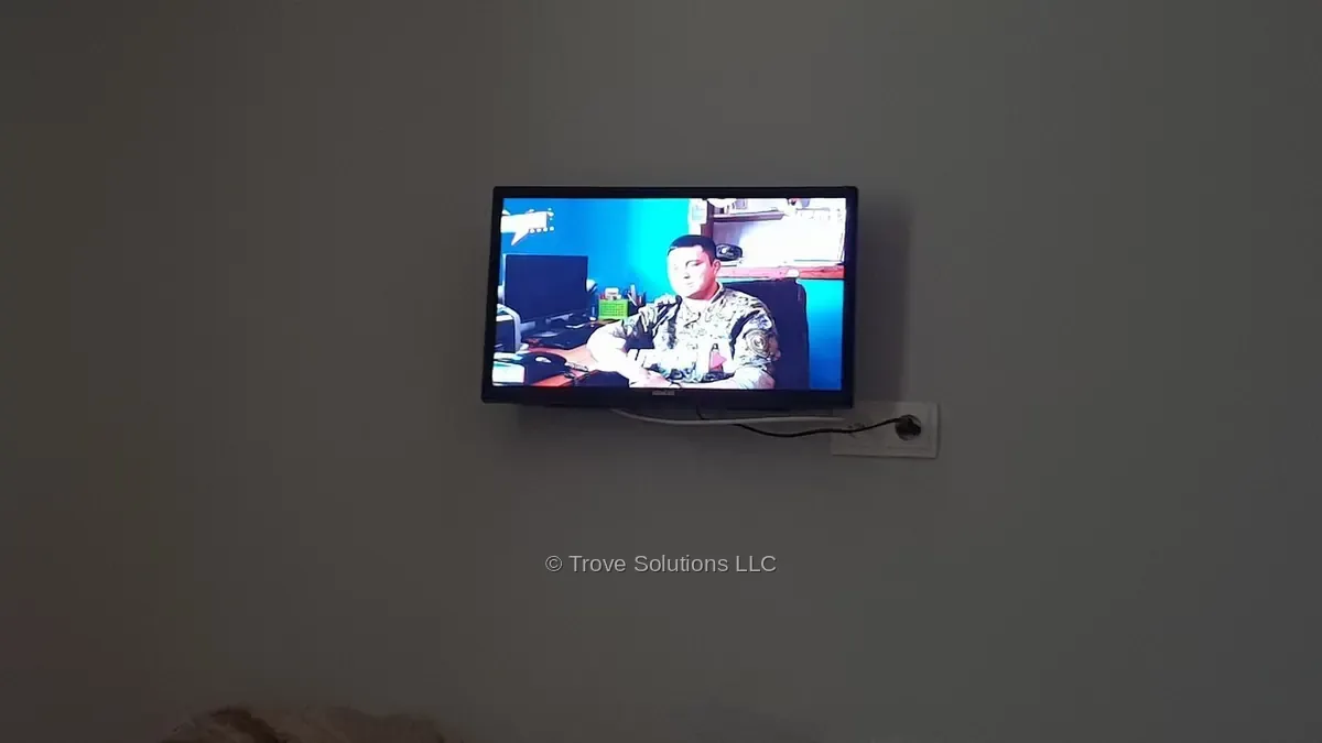 Small TV mounted on a bedroom wall in a Manhattan apartment