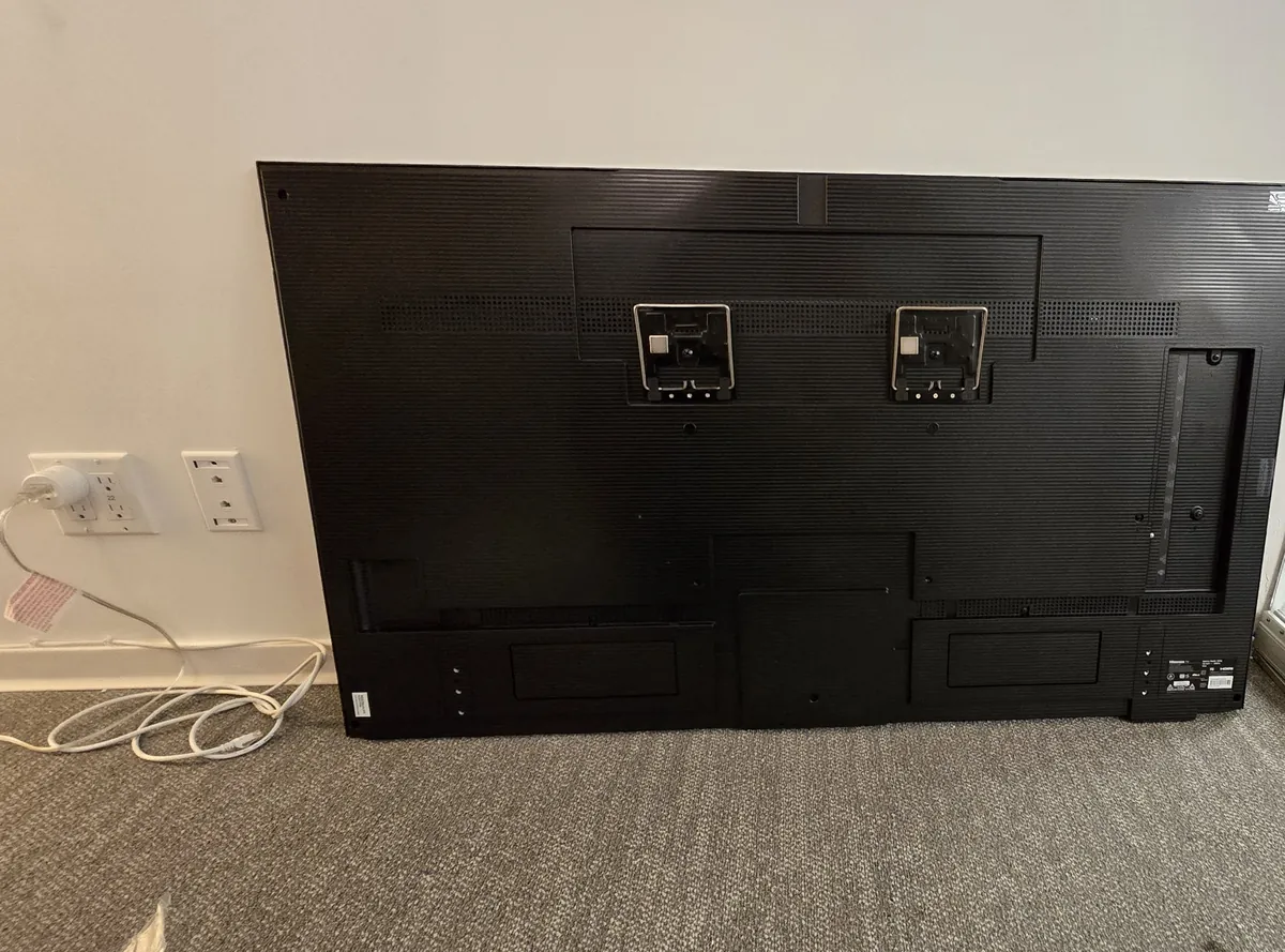 Back of a 55-inch Hisense CanvasTV with two metal mounting brackets attached