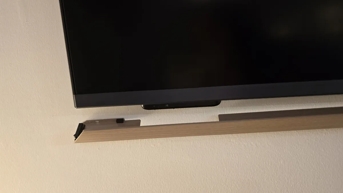 Bottom frame piece with a cutout around the input panel under the TV