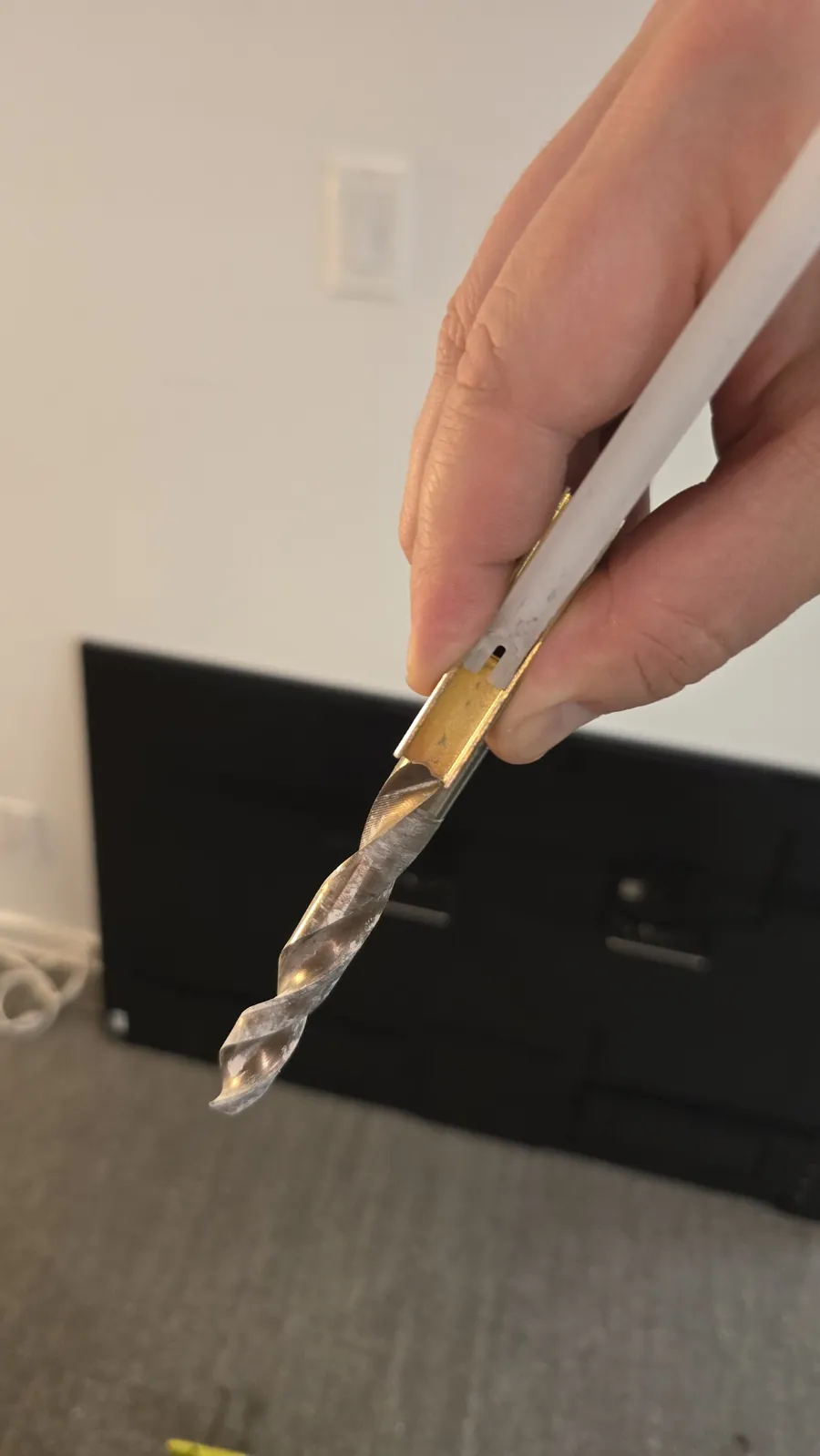 Drill bit next to a flip toggle bolt, showing the hole size it needs