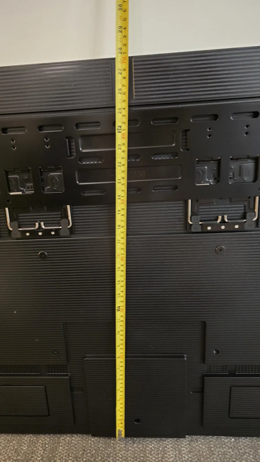 Tape measure from the Hisense wall mount down to the bottom edge of the TV