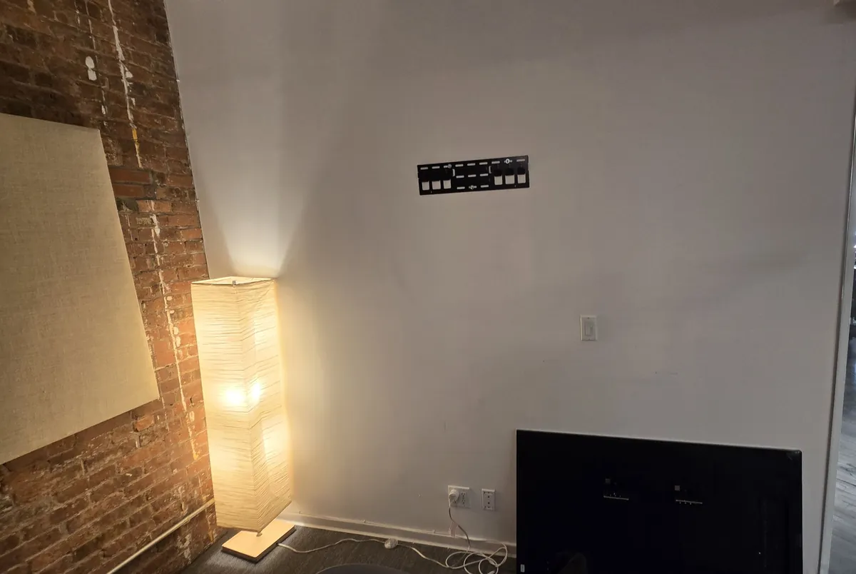 Hisense wall mount plate fastened to an office wall, with the TV waiting below