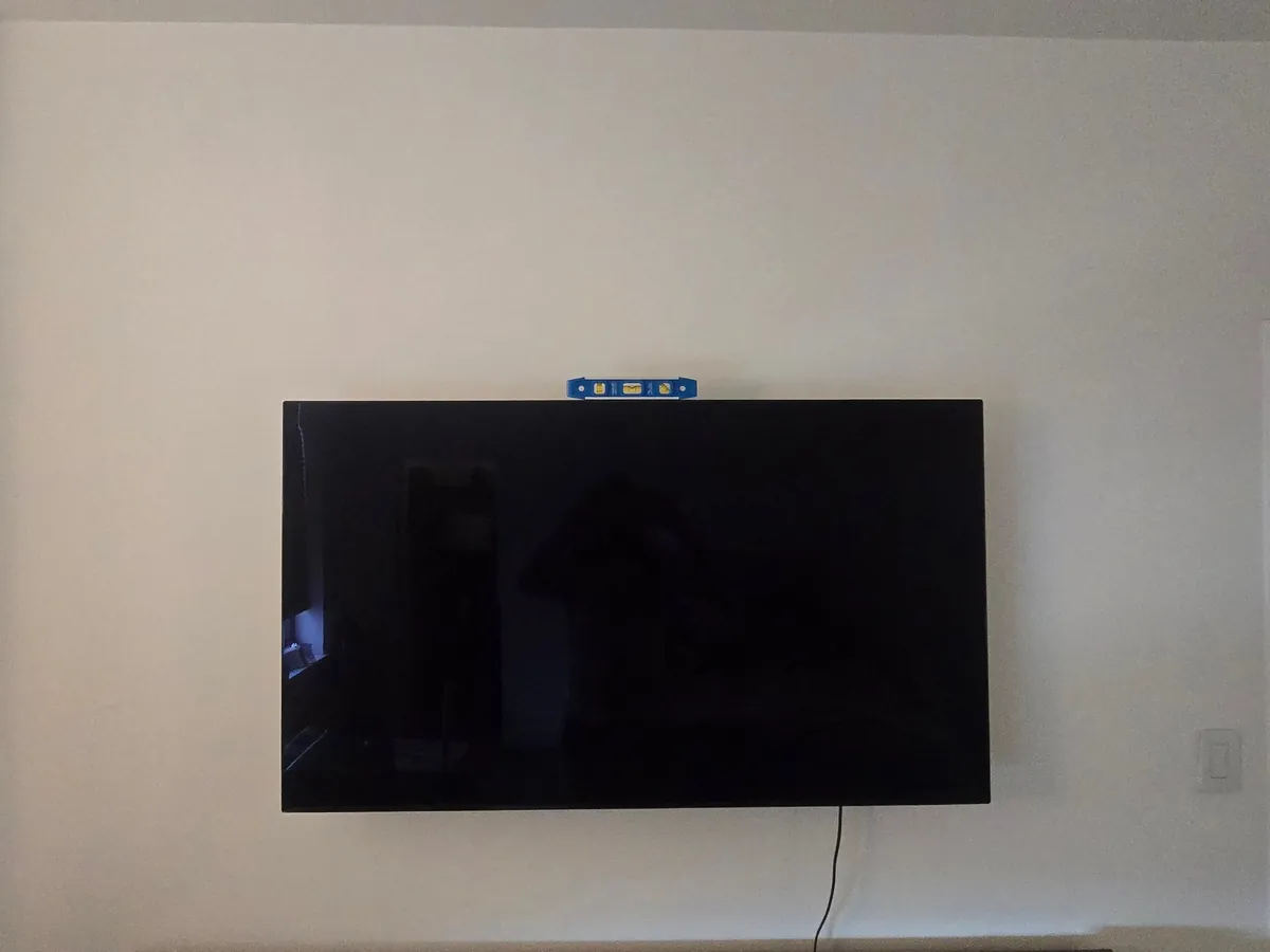 Large TV mounted level on a white wall
