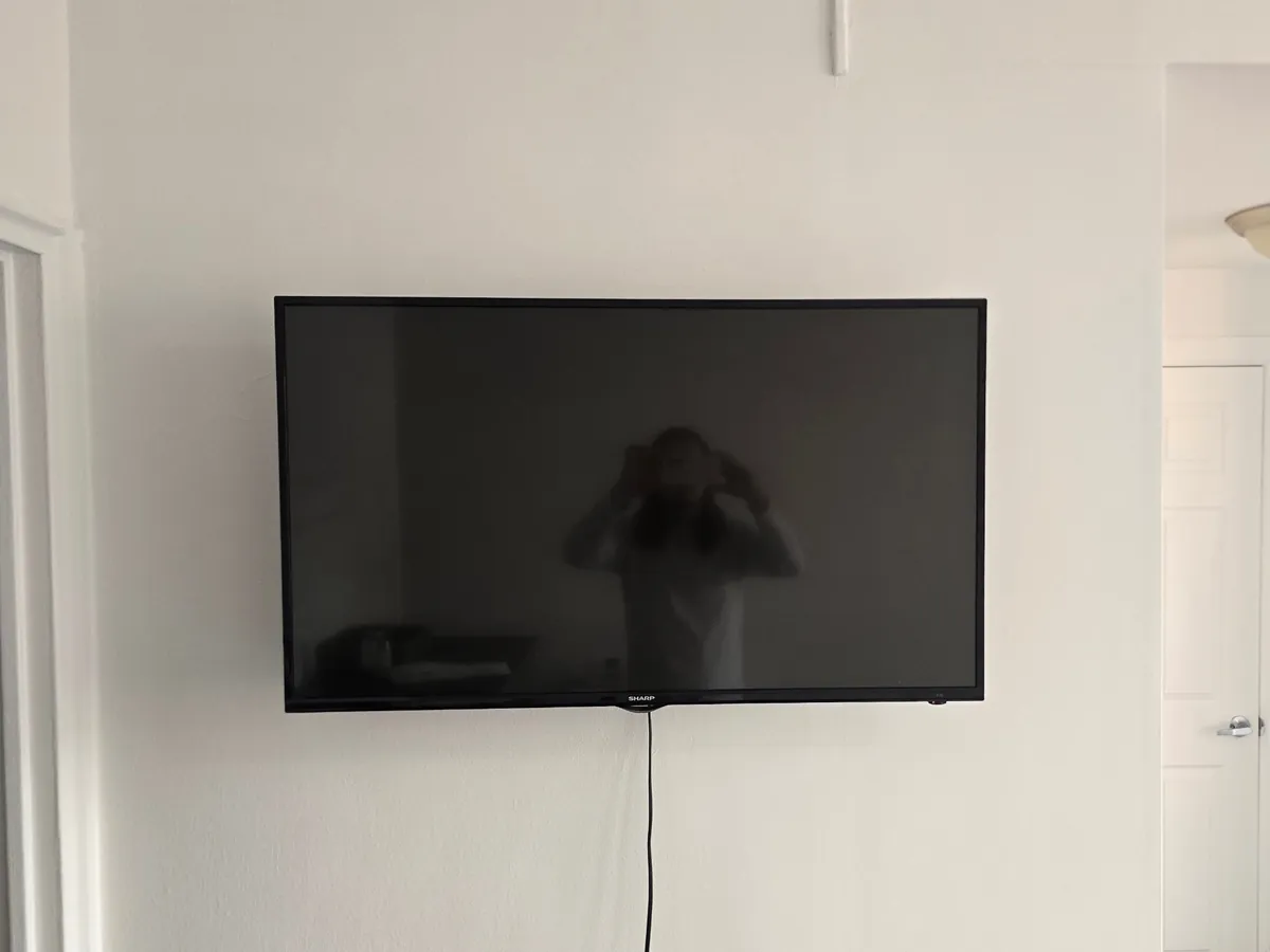 Sharp TV flat-mounted on a white wall