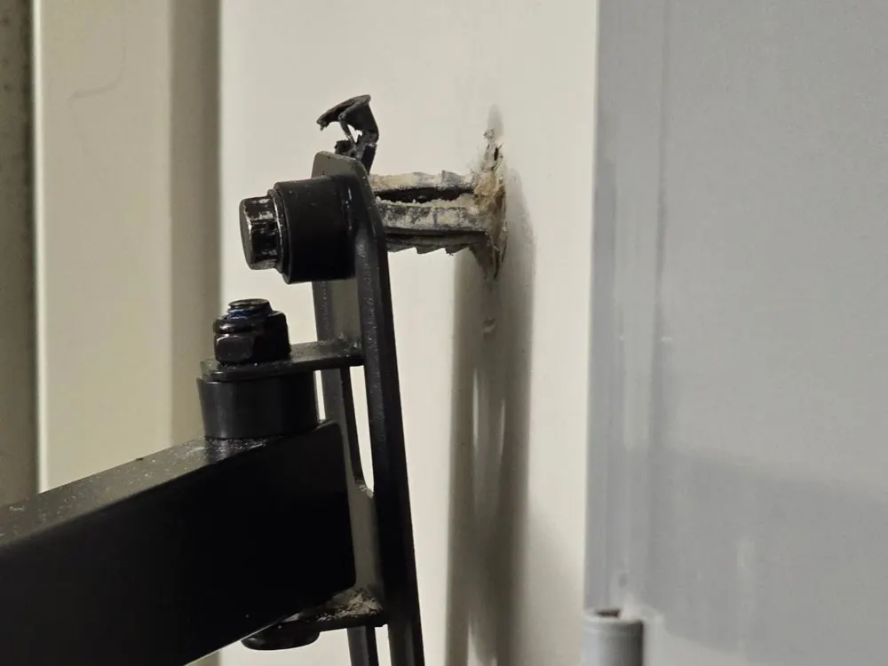 A previous installer's drywall anchor pulling out of the wall