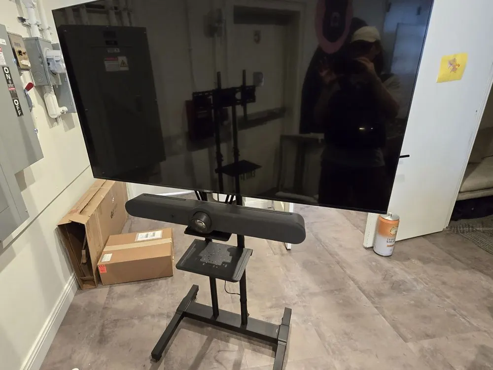 Office TV on a rolling stand with a video-conference bar