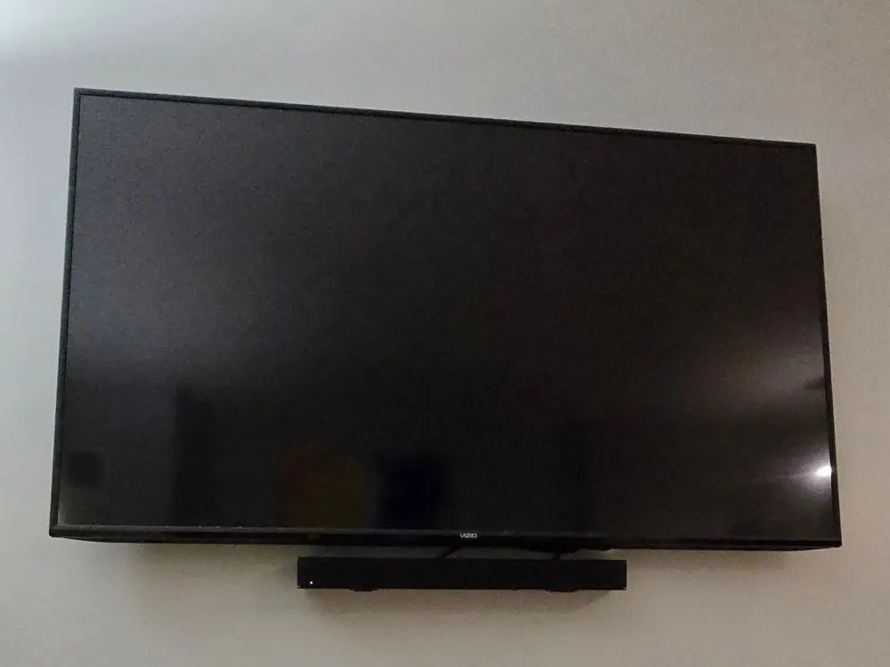 Flat-mounted Vizio TV with a soundbar below