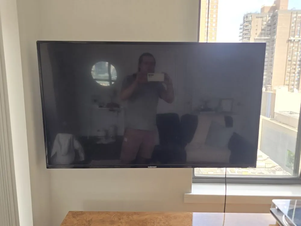 TV mounted in a corner next to a window